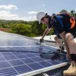 solar-panel-technician-with-drill-installing-solar-panels-on-roof